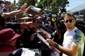 Jenson Button signs autographs for fans.