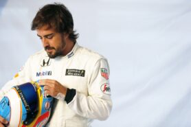 Fernando Alonso prepares his helmet in the garage.