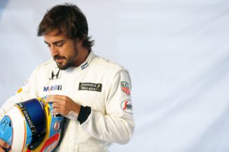 Fernando Alonso prepares his helmet in the garage.