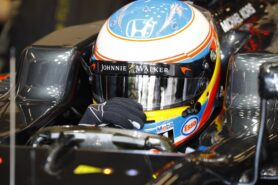 Fernando Alonso adjusts his visor in the cockpit.
