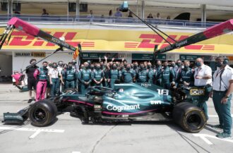 피트 레인에 있는 팀원들과 함께 있는 Aston Martin AMR21